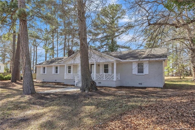 view of front of house featuring a shingled roof, crawl space, covered porch, and brick siding