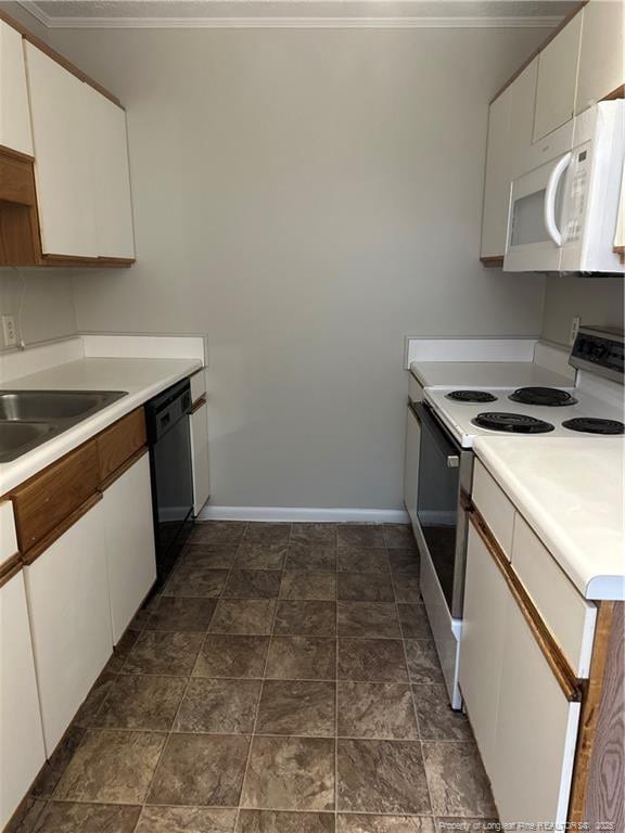 kitchen with white appliances, baseboards, white cabinets, and a sink