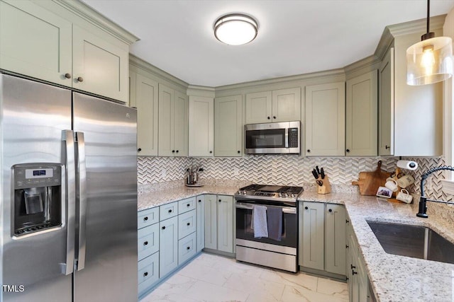 kitchen featuring appliances with stainless steel finishes, light stone counters, a sink, marble finish floor, and backsplash