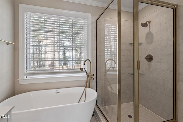 full bath with ornamental molding, a stall shower, and a freestanding tub