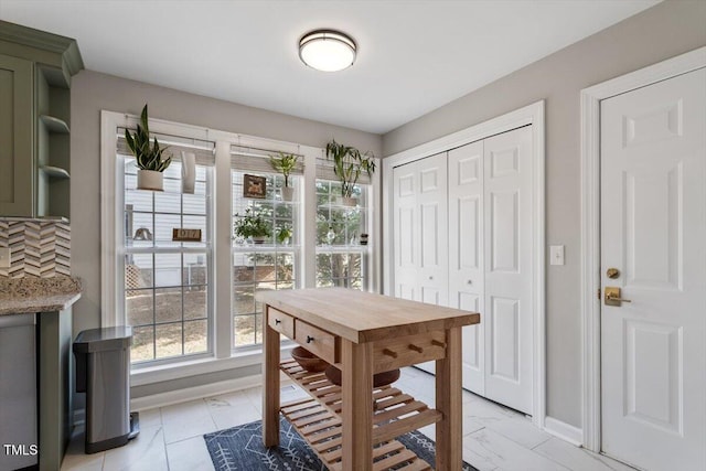 dining space featuring marble finish floor and baseboards