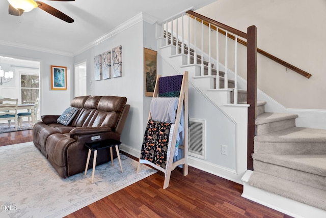 living area featuring crown molding, stairs, visible vents, and wood finished floors