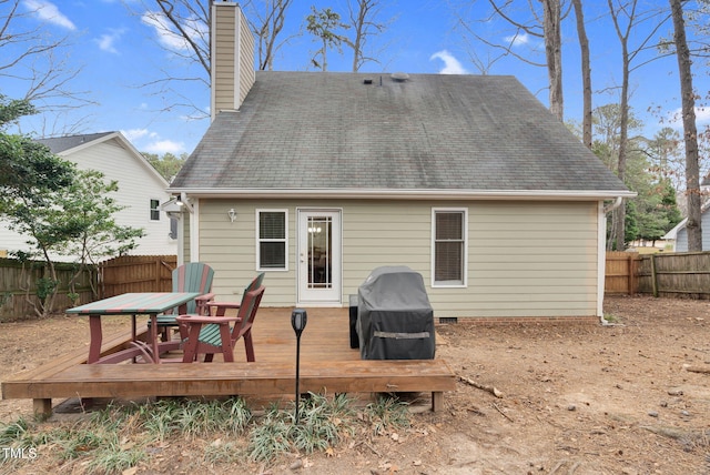 back of property with a deck, crawl space, a chimney, and a fenced backyard