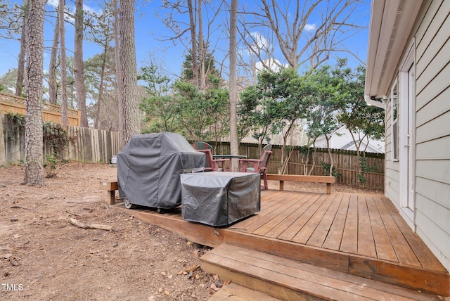 wooden terrace featuring a fenced backyard and a grill