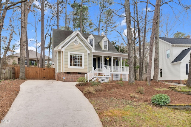 view of front facade featuring roof with shingles, a porch, crawl space, and fence