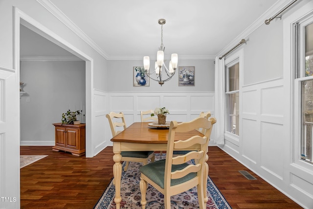 dining room with dark wood-type flooring, visible vents, a decorative wall, and a notable chandelier