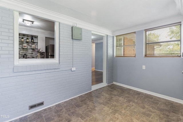 spare room featuring baseboards, visible vents, and ornamental molding