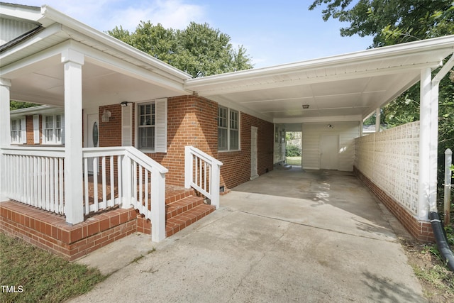 exterior space with driveway, an attached carport, and a porch