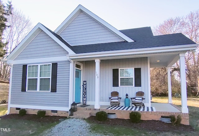 bungalow-style house featuring covered porch, crawl space, and roof with shingles