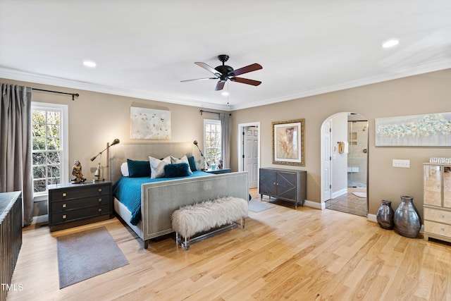 bedroom featuring light wood-type flooring, multiple windows, and arched walkways