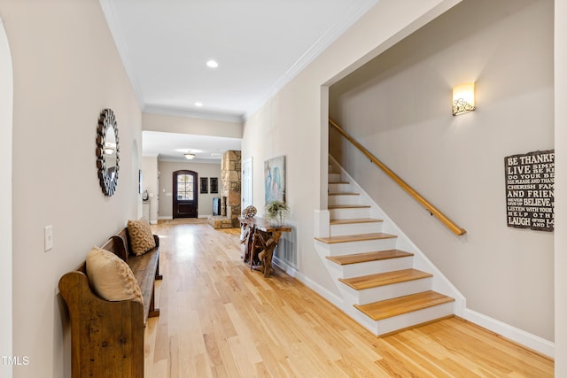 foyer featuring baseboards, wood finished floors, stairs, crown molding, and recessed lighting