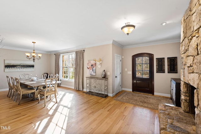 entryway featuring ornamental molding, light wood-style flooring, and baseboards