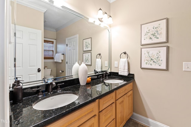 full bath featuring double vanity, a sink, toilet, and crown molding