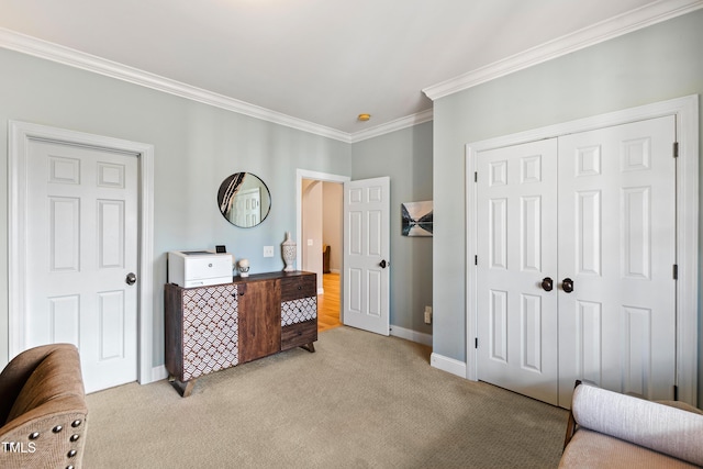 carpeted bedroom featuring a closet, baseboards, and crown molding