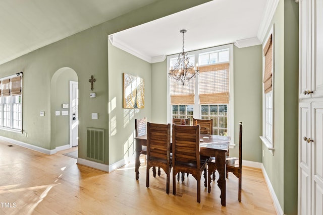 dining space featuring ornamental molding, light wood-type flooring, visible vents, and baseboards