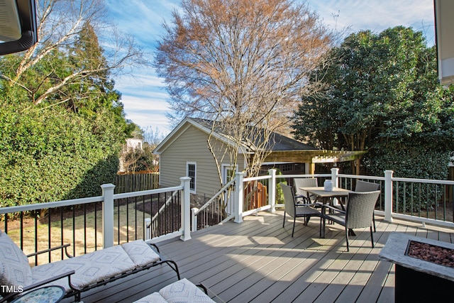 wooden deck featuring a fire pit and outdoor dining area