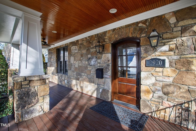 entrance to property featuring stone siding and covered porch