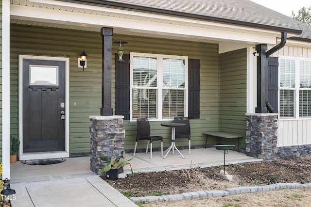 doorway to property with covered porch and roof with shingles