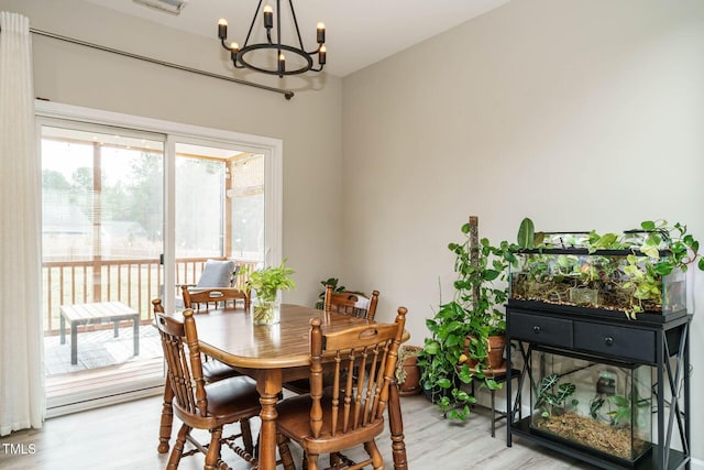 dining space with a chandelier, visible vents, and light wood-style flooring