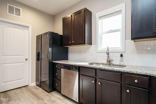 kitchen with light wood finished floors, visible vents, dark brown cabinetry, a sink, and dishwasher