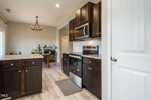 kitchen with stainless steel appliances, light wood-type flooring, dark brown cabinetry, and decorative backsplash