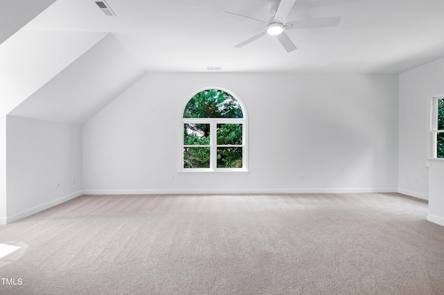 bonus room with lofted ceiling, visible vents, ceiling fan, and light carpet