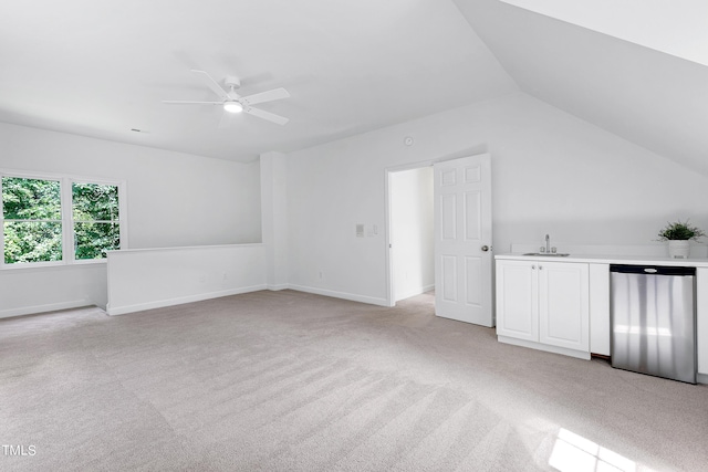 interior space with light carpet, baseboards, ceiling fan, vaulted ceiling, and a sink