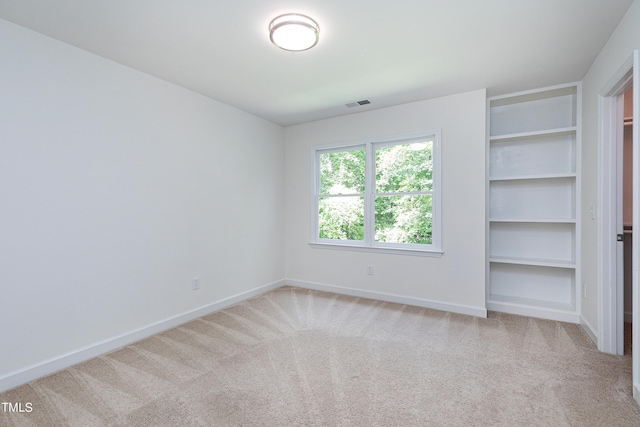 unfurnished bedroom with carpet, visible vents, and baseboards