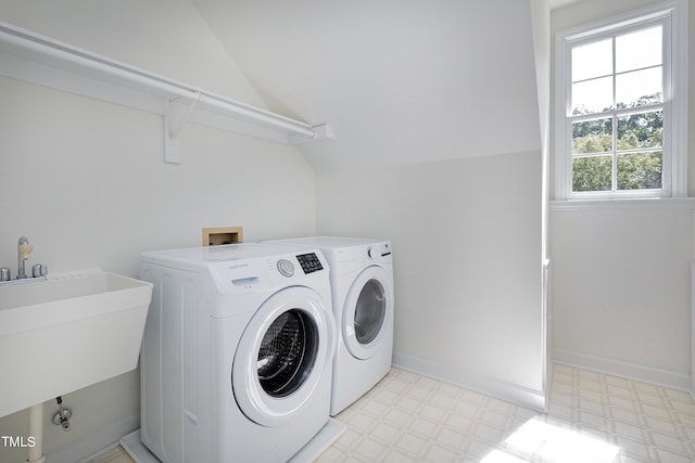 laundry area with washing machine and dryer, laundry area, a sink, baseboards, and light floors