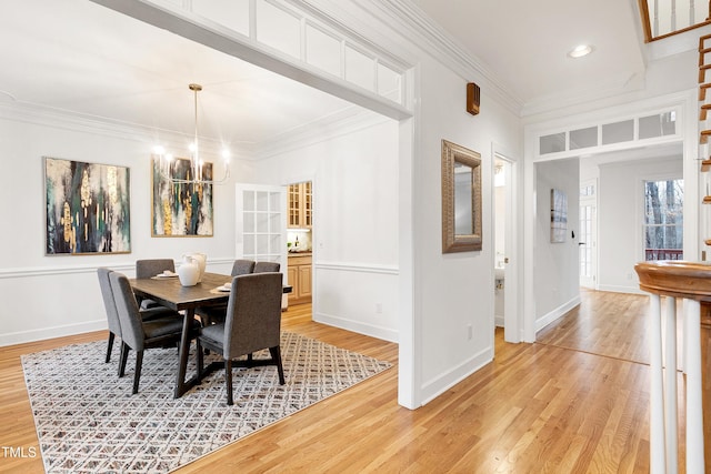 dining space with light wood-style flooring, recessed lighting, baseboards, ornamental molding, and an inviting chandelier