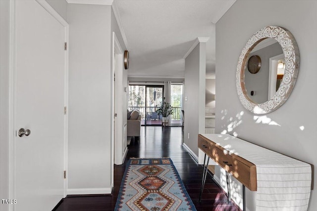 corridor featuring baseboards, ornamental molding, and wood finished floors