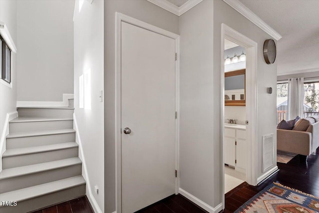 interior space with baseboards, visible vents, ornamental molding, and hardwood / wood-style floors