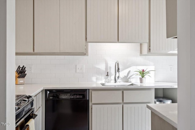 kitchen with light countertops, a sink, backsplash, and black appliances