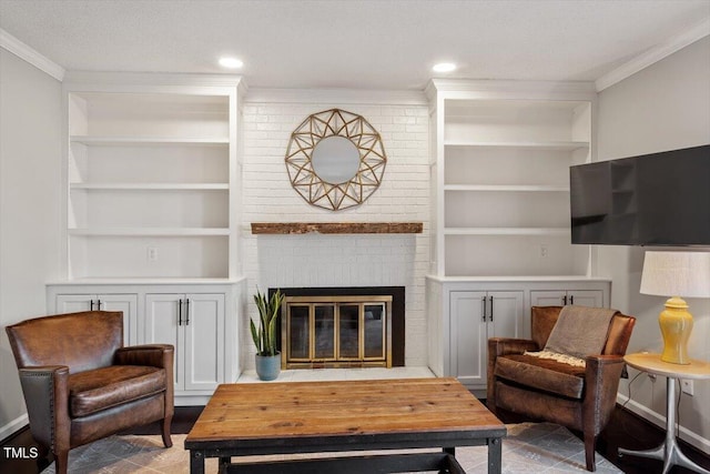 living room with ornamental molding, a brick fireplace, built in shelves, and recessed lighting