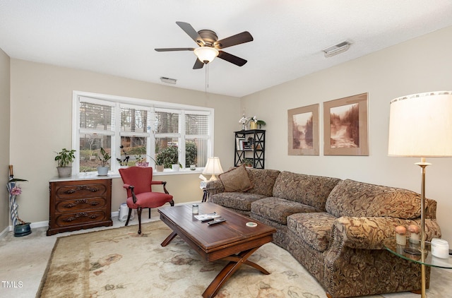 living room featuring visible vents, baseboards, ceiling fan, and carpet floors