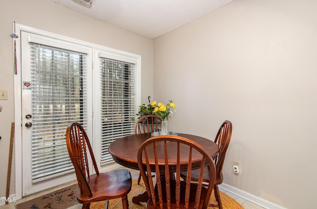 dining area with a textured ceiling and baseboards