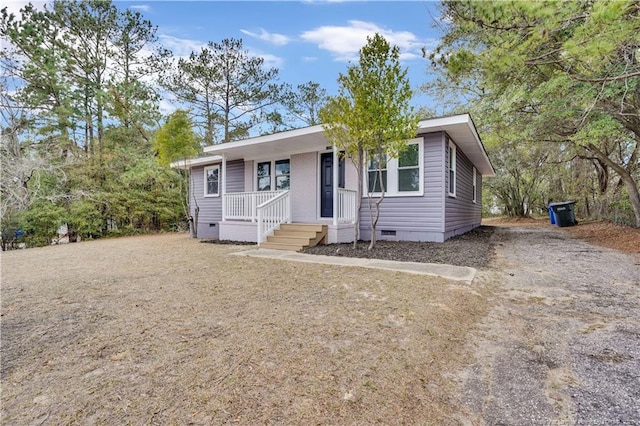 view of front of property with crawl space, covered porch, and dirt driveway