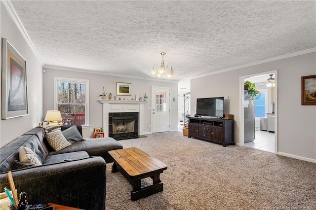 carpeted living area featuring a chandelier, a textured ceiling, a tile fireplace, baseboards, and crown molding