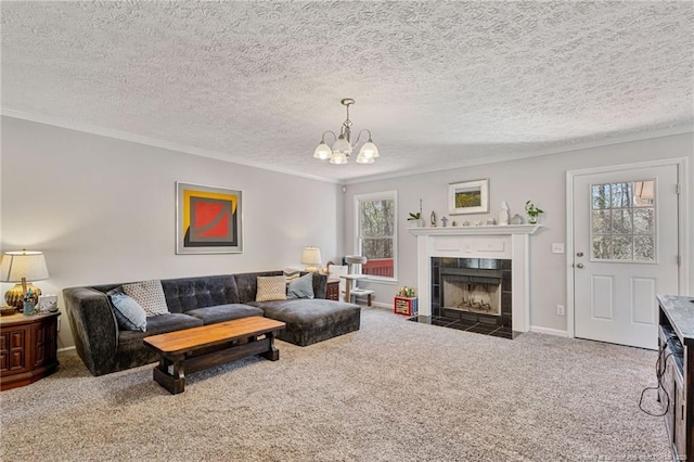 carpeted living area with crown molding, a healthy amount of sunlight, a fireplace, and a notable chandelier