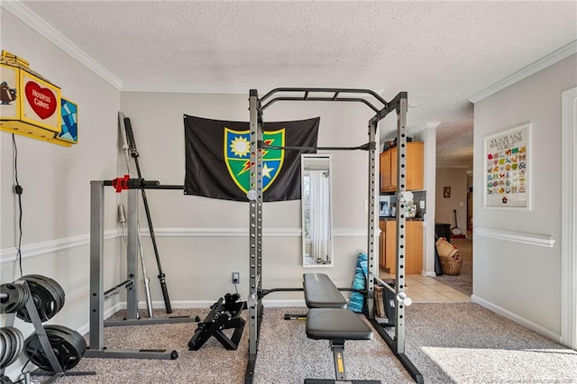 workout area with a textured ceiling, baseboards, and crown molding