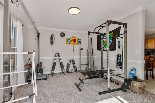 workout room with a textured ceiling, baseboards, and crown molding