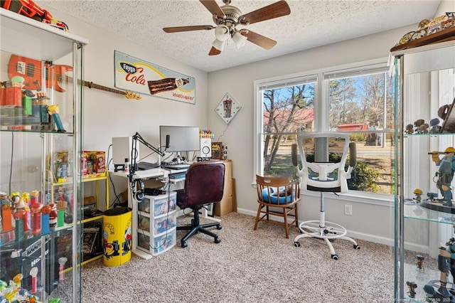 home office with a textured ceiling, carpet floors, ceiling fan, and baseboards