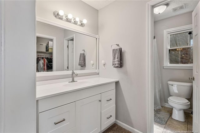 bathroom featuring a textured ceiling, toilet, visible vents, vanity, and baseboards