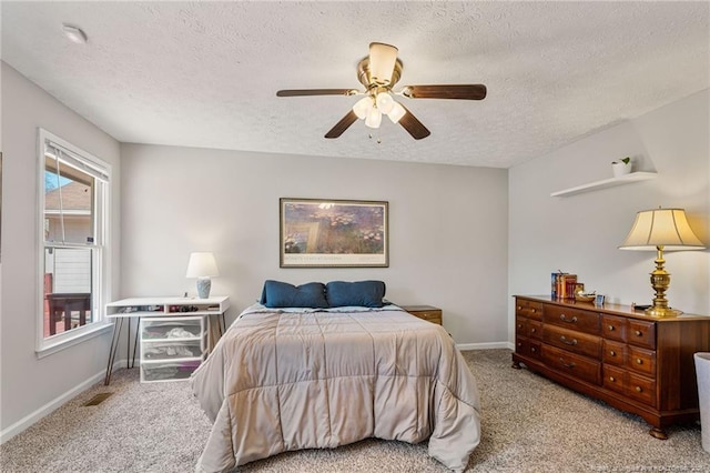 bedroom with ceiling fan, a textured ceiling, baseboards, and carpet flooring