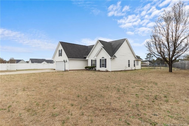 view of side of property featuring a lawn and fence