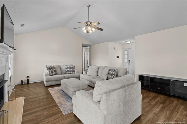 living area featuring visible vents, a ceiling fan, lofted ceiling, a premium fireplace, and dark wood-style flooring