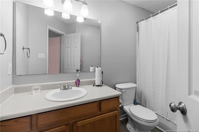 bathroom featuring curtained shower, vanity, and toilet