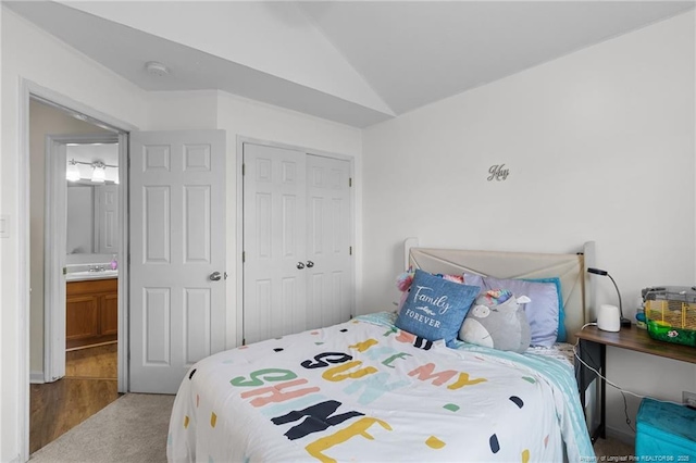 bedroom with lofted ceiling, carpet, and a closet