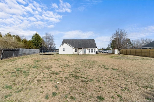 view of yard featuring a trampoline and a fenced backyard