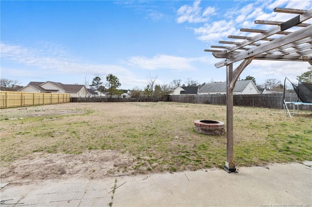 view of yard with a trampoline, an outdoor fire pit, a fenced backyard, and a pergola